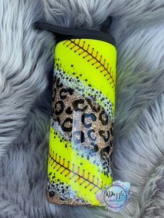 a yellow and black tumbler with leopard print on the side sitting on a furry surface