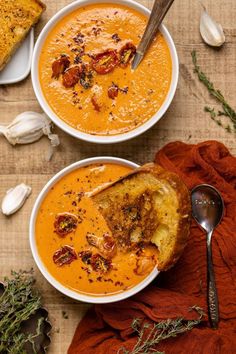 two bowls of soup with bread on the side