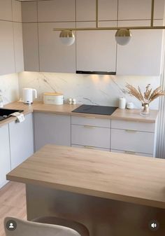 a kitchen with white cabinets and wooden counter tops