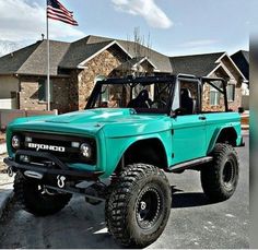 a green truck parked in front of a house