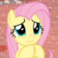 a pink pony with big blue eyes sitting on top of a wooden floor covered in snow