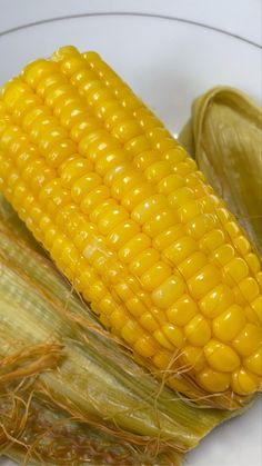 corn on the cob is sitting in a glass bowl