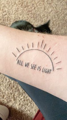 a person with a tattoo on their arm that says, all we see is light