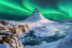 an image of the aurora bore in the sky above some snow covered rocks and water