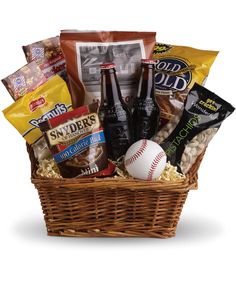 a basket filled with snacks and beer next to a stuffed baseball on top of a table