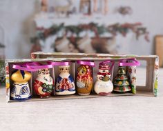 an assortment of small christmas ornaments in a wooden box