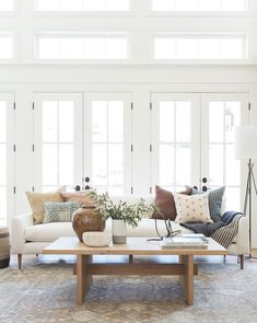 a living room filled with furniture and lots of white walls on the windowsills