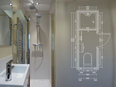 a bathroom with a blueprint on the wall next to a white sink and shower