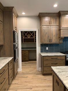 a kitchen with wooden cabinets and marble counter tops