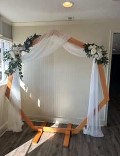 a wedding arch decorated with flowers and greenery