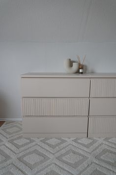 a white dresser sitting on top of a rug