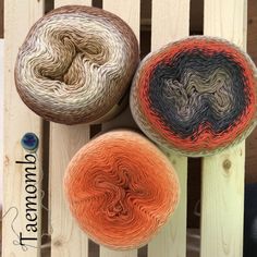 three balls of yarn sitting on top of wooden slats