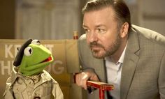 kermie the frog is sitting next to a man in a suit and hat