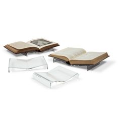 three clear books and one open book on a white background