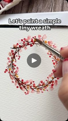 someone is painting a wreath with watercolors on paper