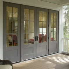 an empty room with french doors and chairs