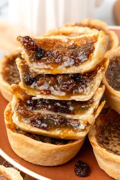 a plate topped with mini pies covered in jelly and raisins on top of each other