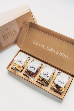 an open box that has some kind of food in it and the words go on, take a bite