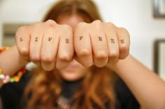 a woman holding her fingers up with the words live free written on it in front of her face