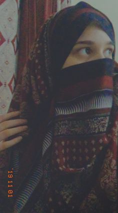 a woman wearing a head scarf and covering her face