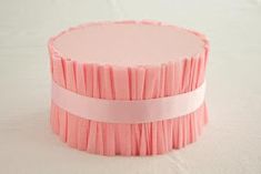 a close up of a pink cake on a white surface