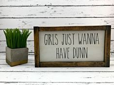 there is a sign that says girls just wanna have dunn'in front of a potted plant