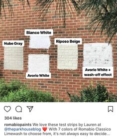 a brick wall with white paint on it and some words written in different languages next to each other