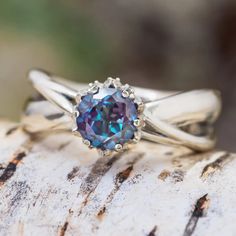 a close up of a ring with a blue stone in it on a piece of wood