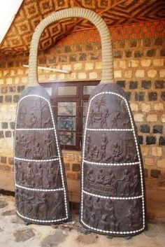 two large brown bags sitting in front of a brick building with carvings on the doors