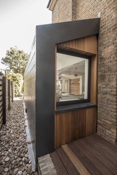 an open window on the side of a brick wall next to a wooden floor and stairs