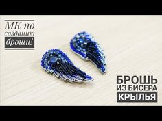 two pairs of blue and silver earrings on a wooden surface, with beads in the shape of an angel's wings