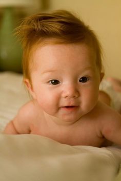 an adorable baby laying on top of a bed