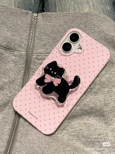 a cell phone case with a black cat on it and a pink polka dot design