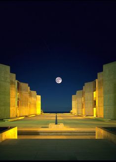 an empty courtyard at night with the moon in the sky