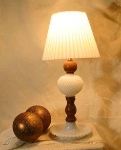 a lamp that is sitting on top of a table next to two balls and a cloth