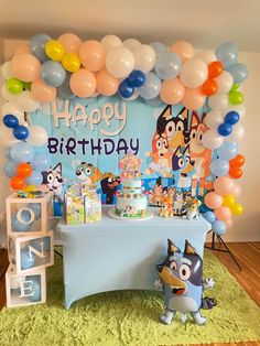 a birthday party with balloons and decorations on the table, including an animal themed cake