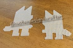 two white plastic cut outs sitting on top of a wooden table