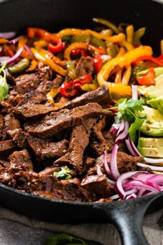 a skillet filled with beef and vegetables