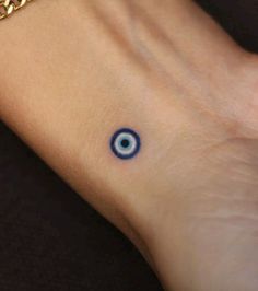 an evil eye tattoo on the wrist