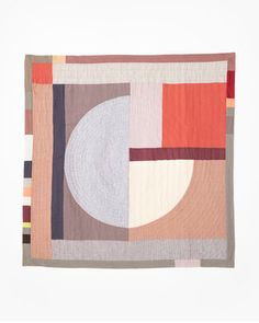 a square quilt with an abstract design on the front and back, in various colors