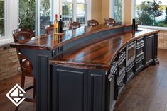 a large wooden counter top sitting in the middle of a kitchen next to a window