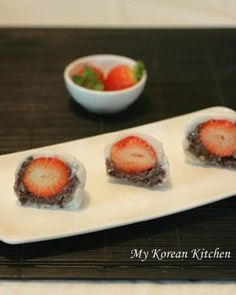 three pieces of sushi on a plate with strawberries