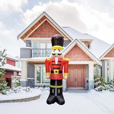 a large inflatable nutcracker is standing in front of a house with snow on the ground