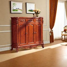 a living room with a chair, table and pictures on the wall above it's doors