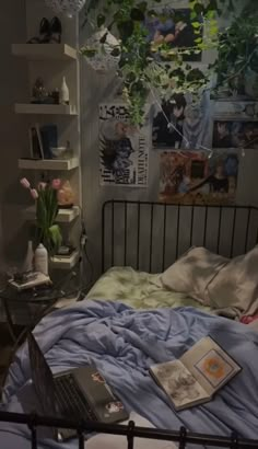 a bed room with a laptop computer on top of it next to a book shelf