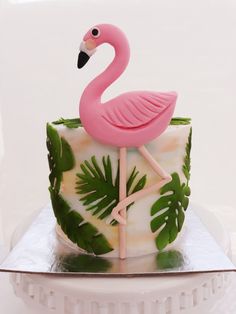 a pink flamingo cake sitting on top of a white plate