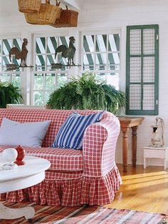 a living room filled with furniture and lots of plants on the windows sills