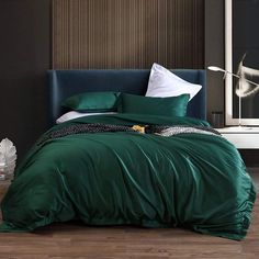 a bed with green sheets and pillows in a room