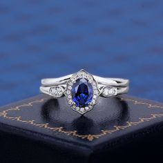 a blue and white diamond ring sitting on top of a book