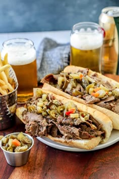 two sandwiches on a plate with french fries and beer